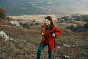 woman in a jacket with a backpack mountains steppe landscape autumn warm clothes model photo