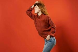 alegre mujer en rojo suéter posando Moda estudio aislado antecedentes foto