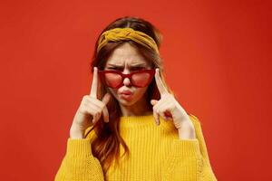 pretty woman in yellow sweater red glasses studio fashion posing photo