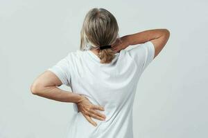 elderly woman back pain back view health problems photo