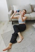 Happy smile woman holding an old camera and taking pictures of herself as a weekend photographer in home clothes with a short haircut hair without filters on a white background, free copy space photo