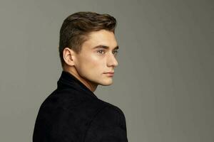 Handsome young guy fashionable hairstyle black jacket attractive look luxury model close-up photo