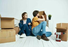 man and woman moving apartment flower potted and boxes repair tools photo