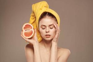 Beautiful woman with a towel on her head bared shoulders grapefruit Skin care photo