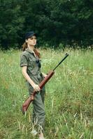 Woman Green jumpsuit black cap weapon hunting weapons photo
