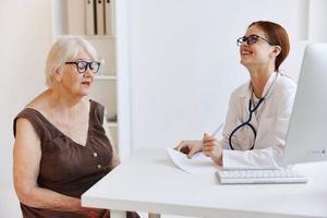 elderly woman with glasses talking to a doctor health care photo