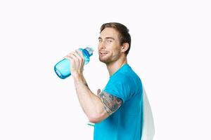 sport man with tattoo on his arm workout water bottle cropped view light background photo