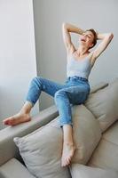 Young woman with short haircut hair having fun at home on the couch smile and happiness, vacation at home, natural posing without filters, free copy space photo