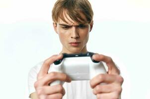 chico en un blanco camiseta con un palanca de mando en su manos juegos entretenimiento pasatiempo foto