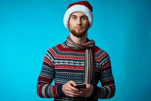 alegre hombre con un teléfono en mano fiesta Navidad tecnología azul antecedentes foto