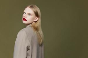 blonde woman with red lips holds hand near face isolated background photo