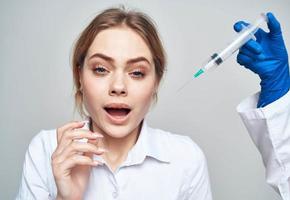 female patient smiling and a syringe in the hands of the doctor botox injection photo