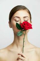 Woman with flower with closed eyes sniffing a rose charm photo