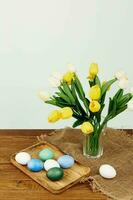 vistoso huevos en un bandeja amarillo flores fiesta Pascua de Resurrección foto