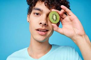 funny curly guy with kiwi in his hands emotions fruit studio photo