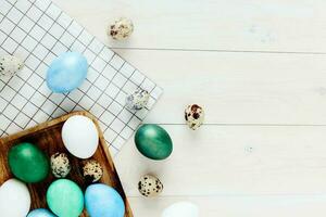 Easter holiday colorful eggs on a wooden table checkered fabric top view photo