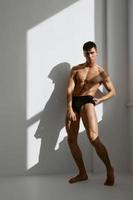 man with muscular body black panties posing studio photo