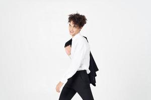 handsome young man in classic suit with jacket in hand on light background cropped view photo