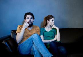 Offended woman on the couch in the evening watching TV and a man photo