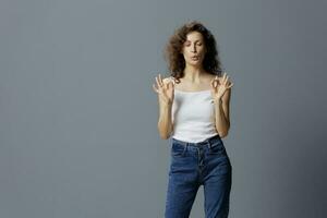 Irritated angry curly beautiful woman in basic white t-shirt exhales trying to calm down show AUM Okay gesture posing isolated on gray blue background. People Lifestyle Emotions concept. Copy space photo