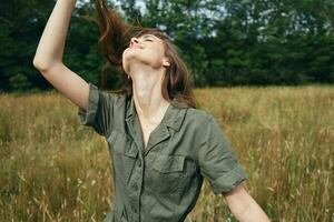 alegre mujer en verde mono es participación su pelo disfrutando foto