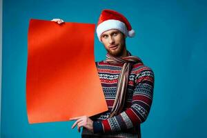 emotional man in a santa hat holding a banner holiday blue background photo