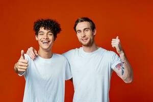 dos hombre en blanco camisetas divertido emociones mano gestos amistad abrazos foto