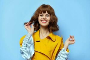 portrait of woman in yellow coat with blue striped lines laughing emotions photo