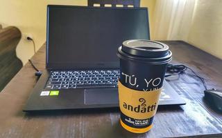 Playa del Carmen Quintana Roo Mexico 2021 Coffee to go cup of black coffee and laptop notebook. photo