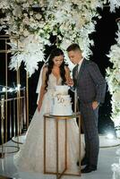 newlyweds happily cut and taste the wedding cake photo