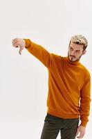 man in sweater showing thumb down displeased emotion light background photo