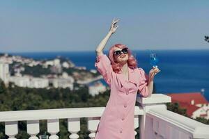 glamorous woman in a pink dress in sunglasses with a cocktail Relaxation concept photo