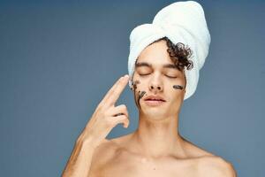 guy with a towel on his head face cream skin care photo