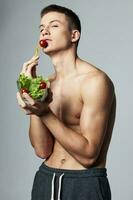 hombre con un plato de ensalada comiendo energía estilo de vida aislado antecedentes rutina de ejercicio foto