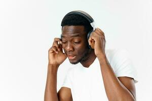hombre de africano apariencia en auriculares música amante ligero antecedentes foto