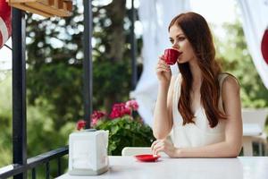 alegre mujer sentado en un al aire libre café desayuno relajación concepto foto