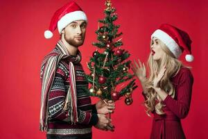 young married couple Christmas tree toys holiday joy red background photo