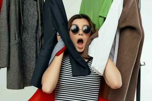 cheerful woman with glasses trying on clothes shop retail isolated background photo