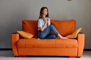 retrato de un mujer auricular a hogar en el sofá entretenimiento tecnologías foto