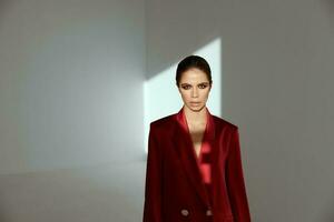 pretty brunette in gray room and red jacket portrait photo