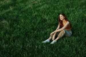 Woman sitting on green grass in nature in a park, view from above photo