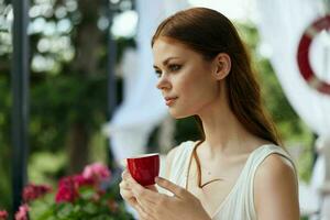 retrato de joven hermosa mujer Bebiendo café al aire libre inalterado foto