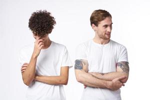 two men in white t-shirts stand side by side cropped view studio friendship photo