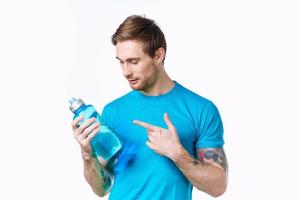 hombre en un azul camiseta con un botella de agua en su mano en un blanco antecedentes Copiar espacio foto