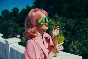 cheerful woman enjoying a colorful cocktail hotel terrace Relaxation concept photo