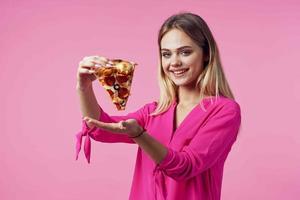 cute cheerful woman pizza in hands snack delicious fast food pink background photo