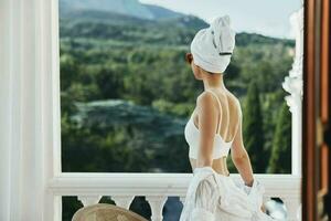 atractivo joven mujer toalla y Gafas de sol en balcón relajación concepto foto