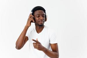 hombre de africano apariencia con cerrado ojos en auriculares escuchando a música foto