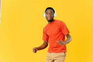 africano hombre vistiendo auriculares música bailando entretenimiento amarillo antecedentes foto