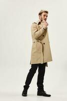 attractive man in beige coat modern style fashion look aside isolated background photo